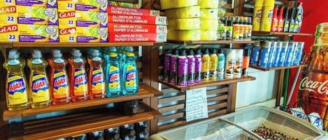 A store with shelves stocked with aluminum foil, paper towels, and cleaning products.