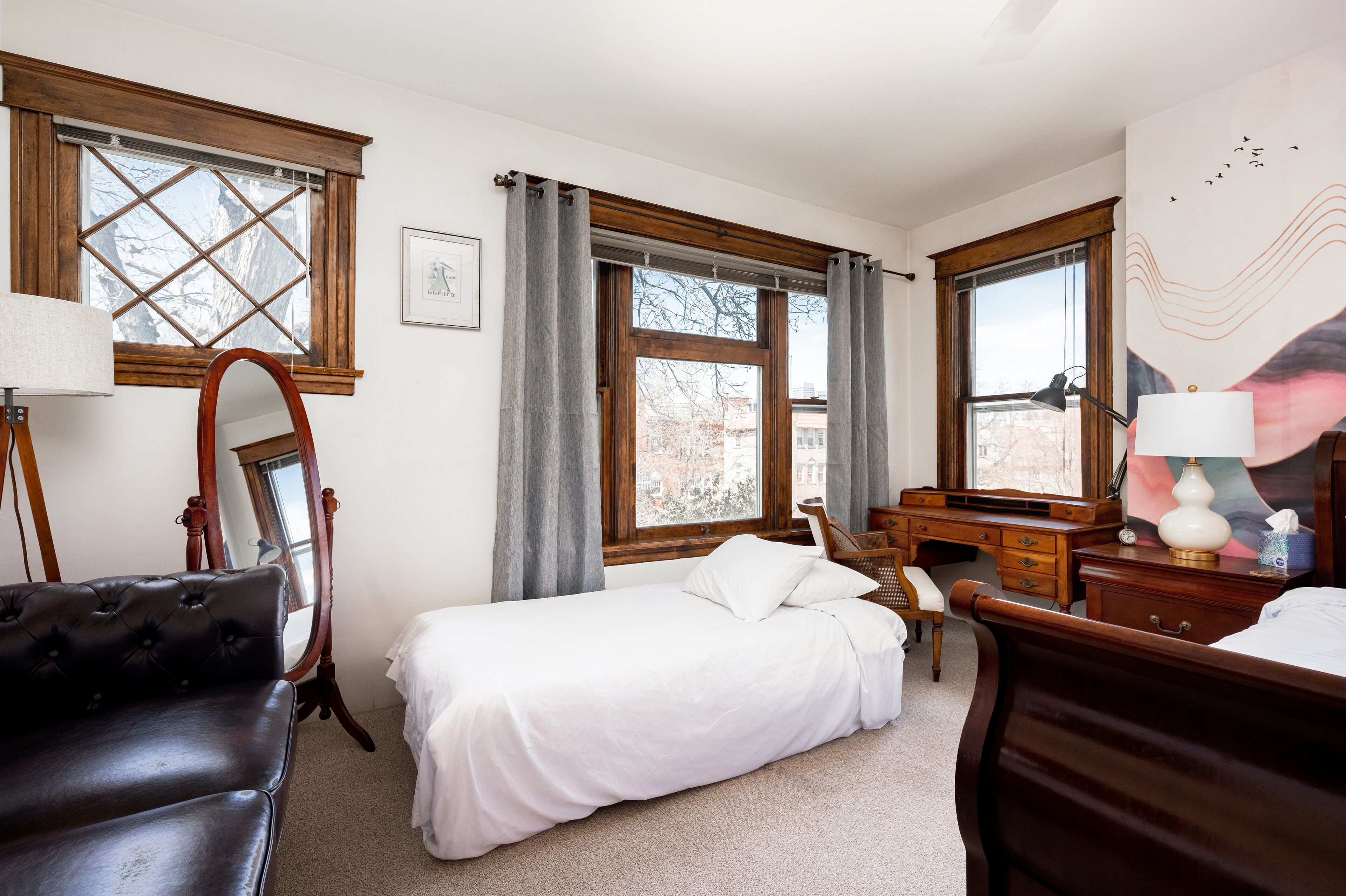 Une chambre à coucher avec un lit, un bureau, une chaise et une commode.