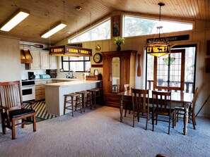 Kitchen features an oven, coffee maker, and dining area with a view of the outdoors.