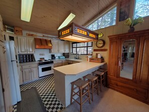 Enjoy cooking in this well-equipped kitchen with a central island and stools for seating, featuring a stove, oven, and sink.