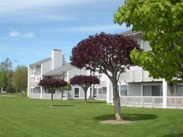 A two-story residential building with a white exterior and a covered front porch.