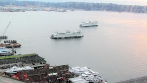Un puerto con varios cruceros amarrados, un muelle con una grúa y edificios al fondo.