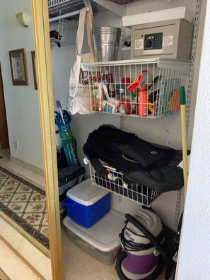 A storage area with shelves, a metal rack, and a blue container.