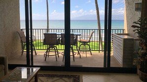 Un balcon avec vue sur l’océan, aménagé avec des chaises et une table.