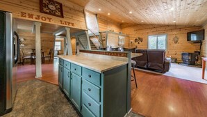 A spacious cabin interior with a kitchen area, dining space, and a living area.