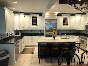 Enjoy cooking in this well-equipped kitchen with a central island, stainless steel appliances, and ample countertop space.