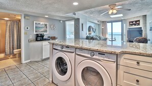 Una cocina moderna con electrodomésticos integrados, un ventanal grande y un ventilador de techo.