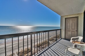 A balcony with a view of the beach and ocean.