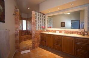 A bathroom with a shower, tiled walls, wooden cabinets, and a large mirror. - COME to the best spot in Mexico!! Celebrate Labor Day In beautiful Los Cabos! (San Jose Del Cabo)