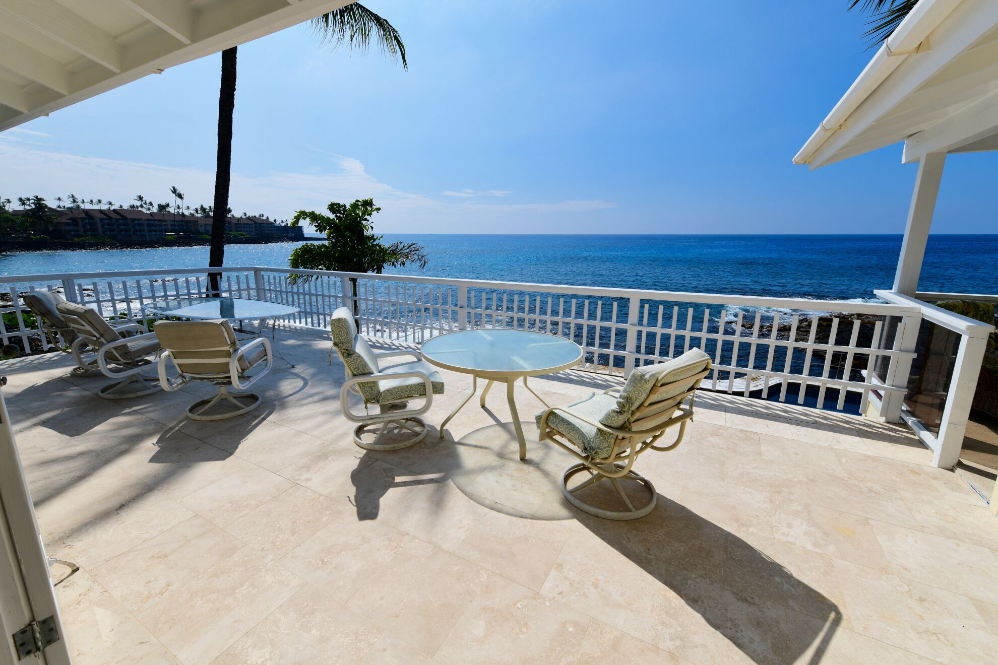 Une terrasse avec une table et des chaises, offrant une vue sur la côte.