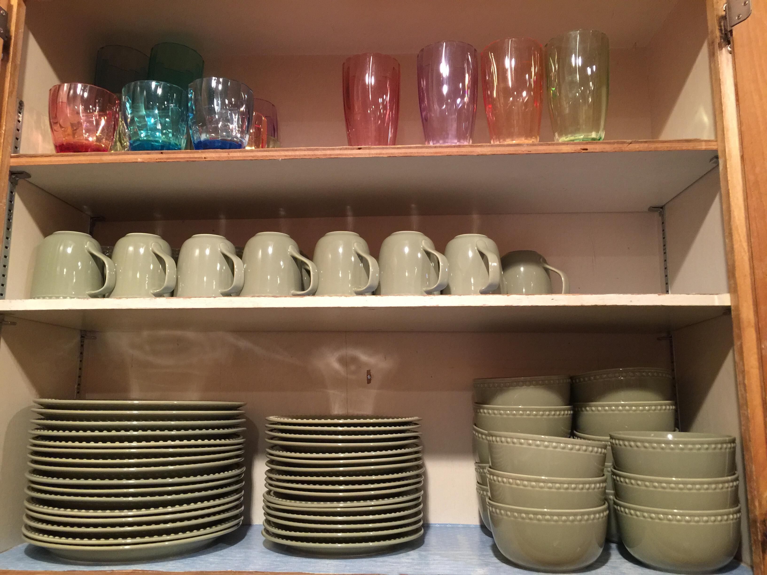 Uno scaffale con tazze e piatti di ceramica.