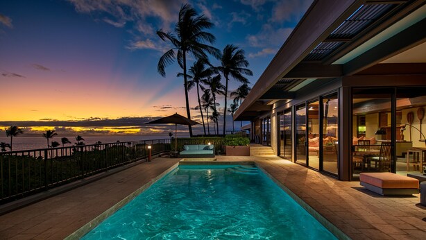 A swimming pool with a view of the ocean at sunset, a covered seating area, and a glass-enclosed lounge. - Mauna Kea Villa, Walking Distance to the Beach and Hotel - Beyond Perfection! (Kamuela)