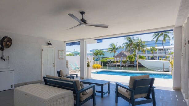 Une chambre avec piscine, un ventilateur de plafond et vue sur l’espace piscine.