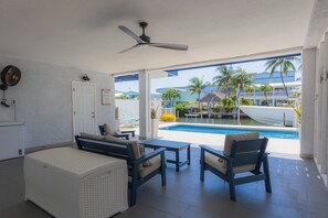 A room with a pool, a ceiling fan, and a view of the pool area. - Angler's Dream charming 2-bedroom, 2-bath half duplex, just minutes from beautiful Sombrero Beach! (Marathon)