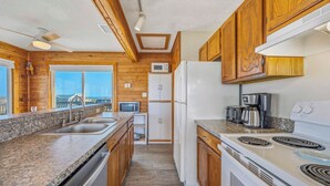A kitchen with granite countertops, wooden cabinets, a refrigerator, a stove, and a microwave. - Oceanview Dog Friendly w/ Hot Tub, Games, Community Pool and Tennis/Pickleball (Avon)
