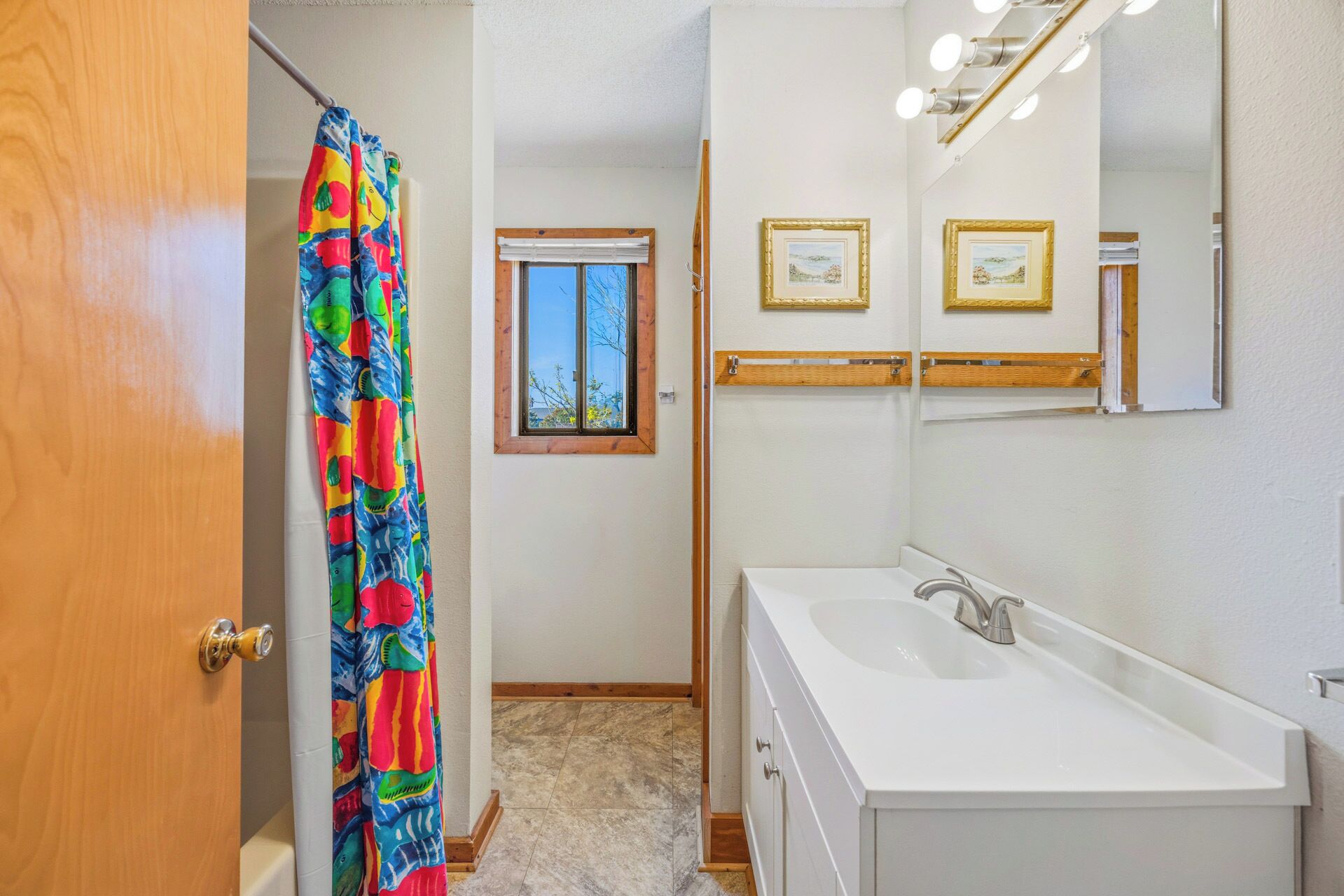 A bathroom with a white sink, a mirror, and a shower curtain.