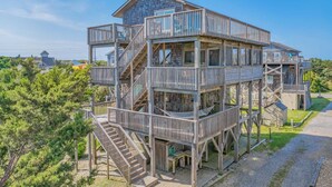A multi-level wooden structure with balconies, a staircase, and a pathway leading to it. - Oceanview Dog Friendly w/ Hot Tub, Games, Community Pool and Tennis/Pickleball (Avon)