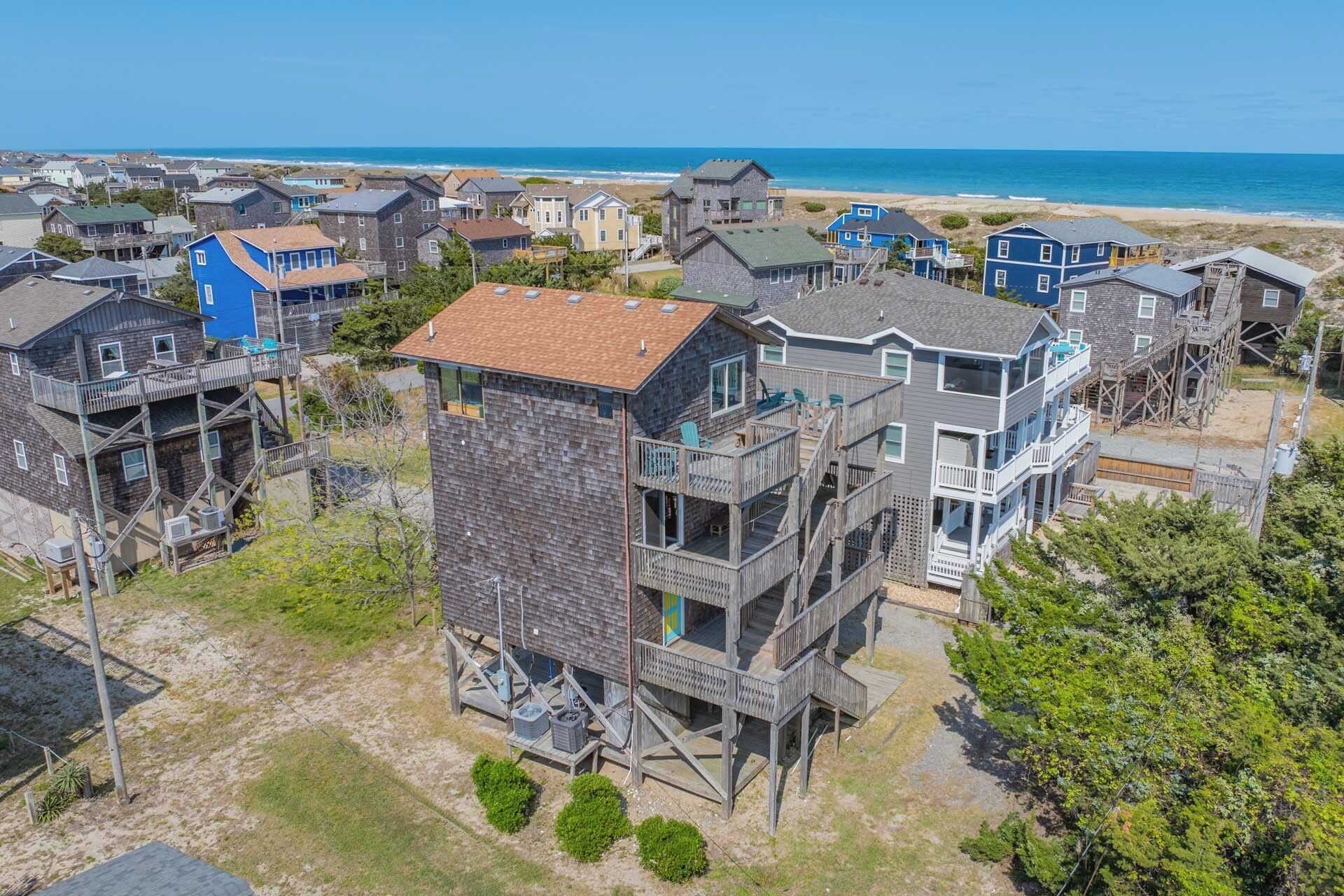 A coastal residential area with multi-story houses featuring balconies and wooden decks.