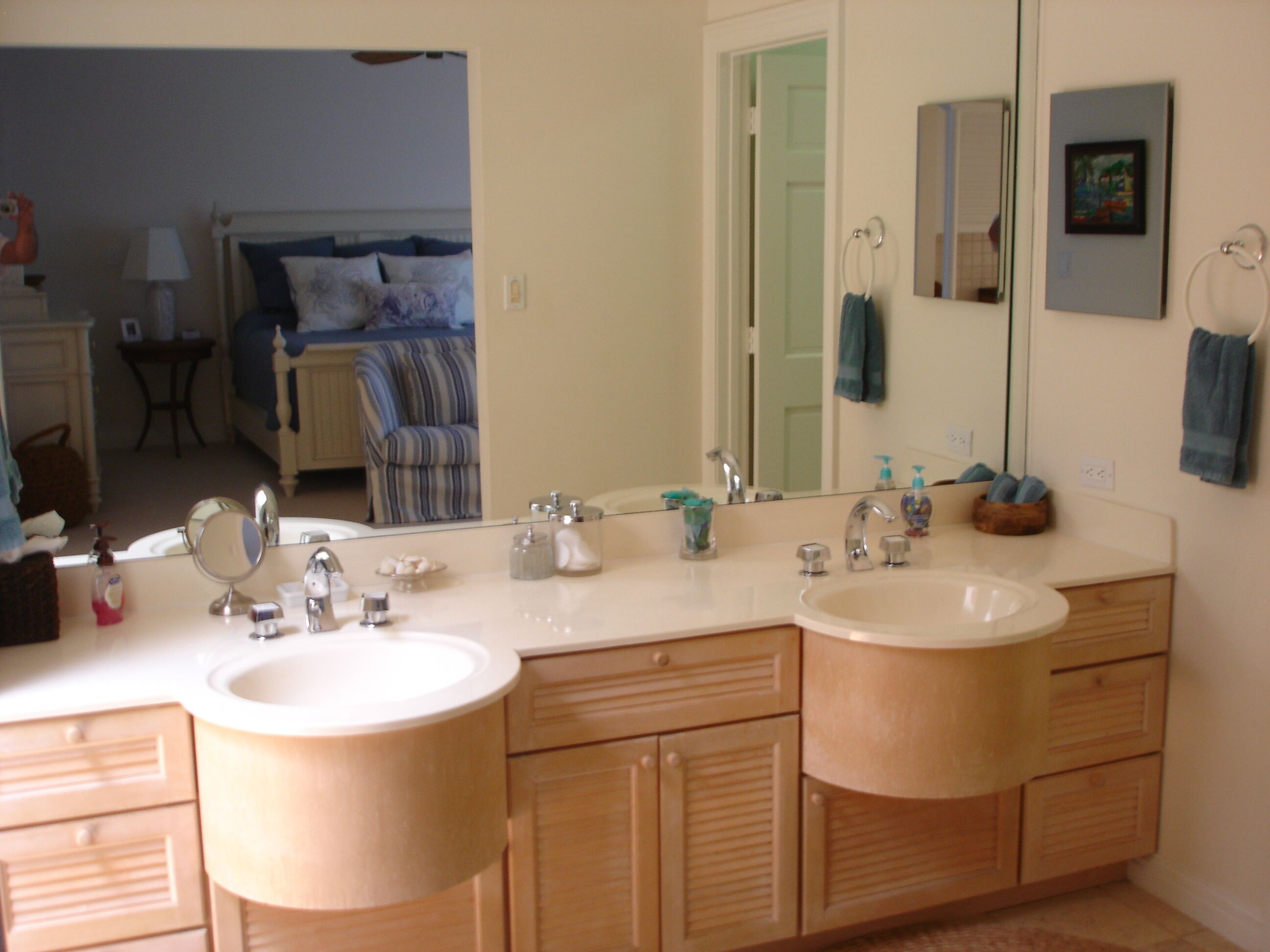 A bathroom with two sinks, a large mirror, and wooden cabinets.