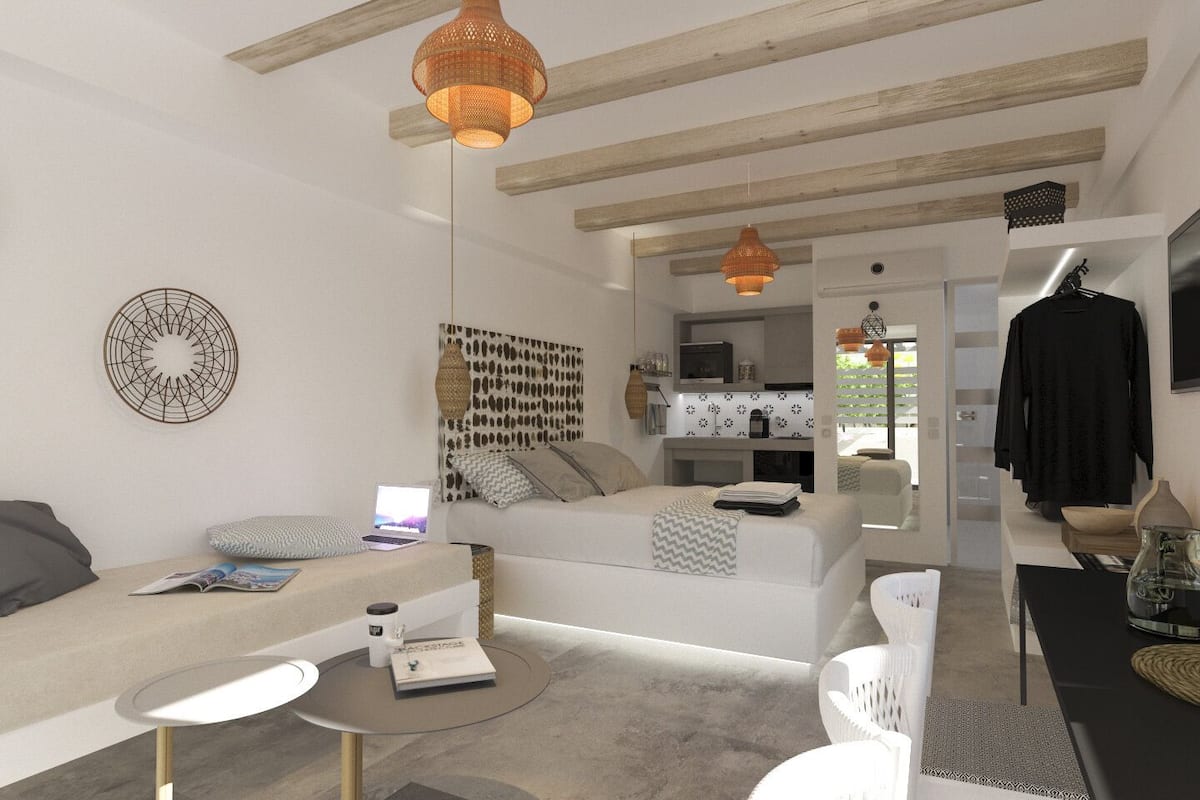 A modern living room with a sofa, a coffee table, and a dining area. There is a kitchen visible in the background.
