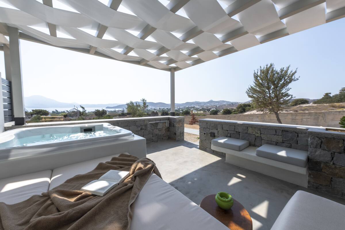 A spa area with a hot tub, seating, and a view of the landscape.