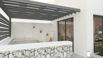 A modern spa area with a stone wall, a bed, and a glass-enclosed room.