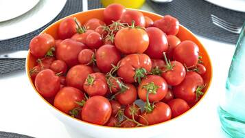 Een schaal verse tomaten op een tafel.