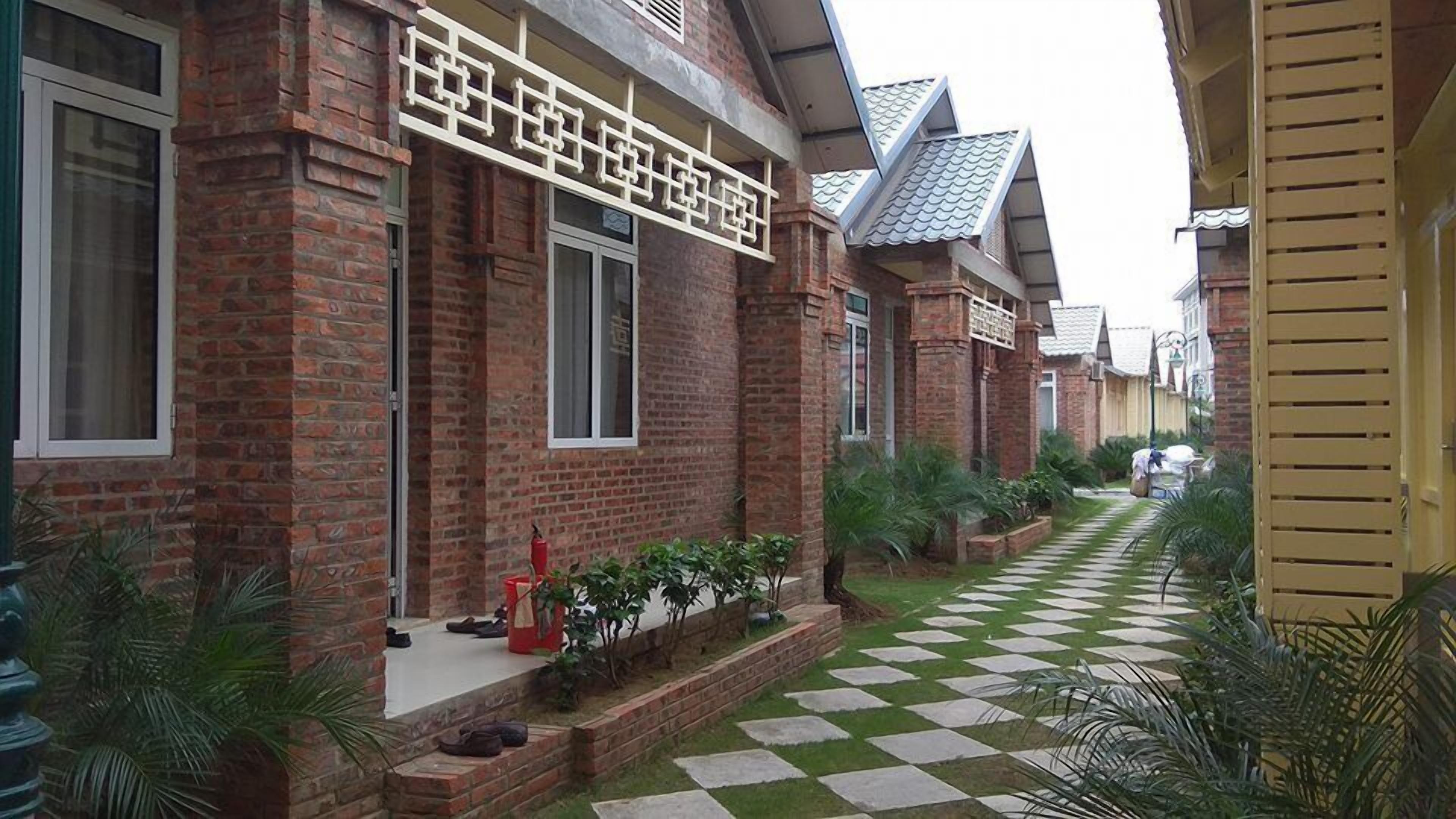 A row of brick houses with a checkered pathway between them.