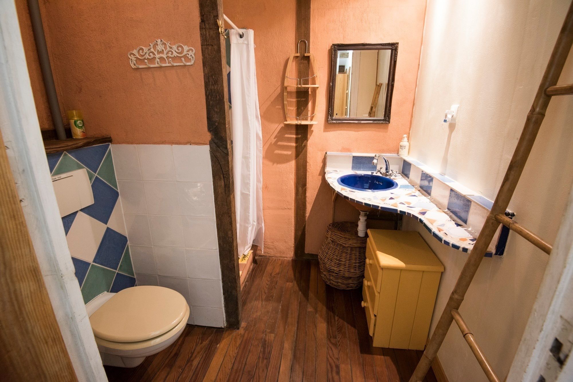 A compact bathroom with a toilet, sink, and mirror.