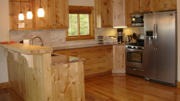 Een moderne keuken met houten kastjes, roestvrijstalen apparatuur en een centraal eiland.
