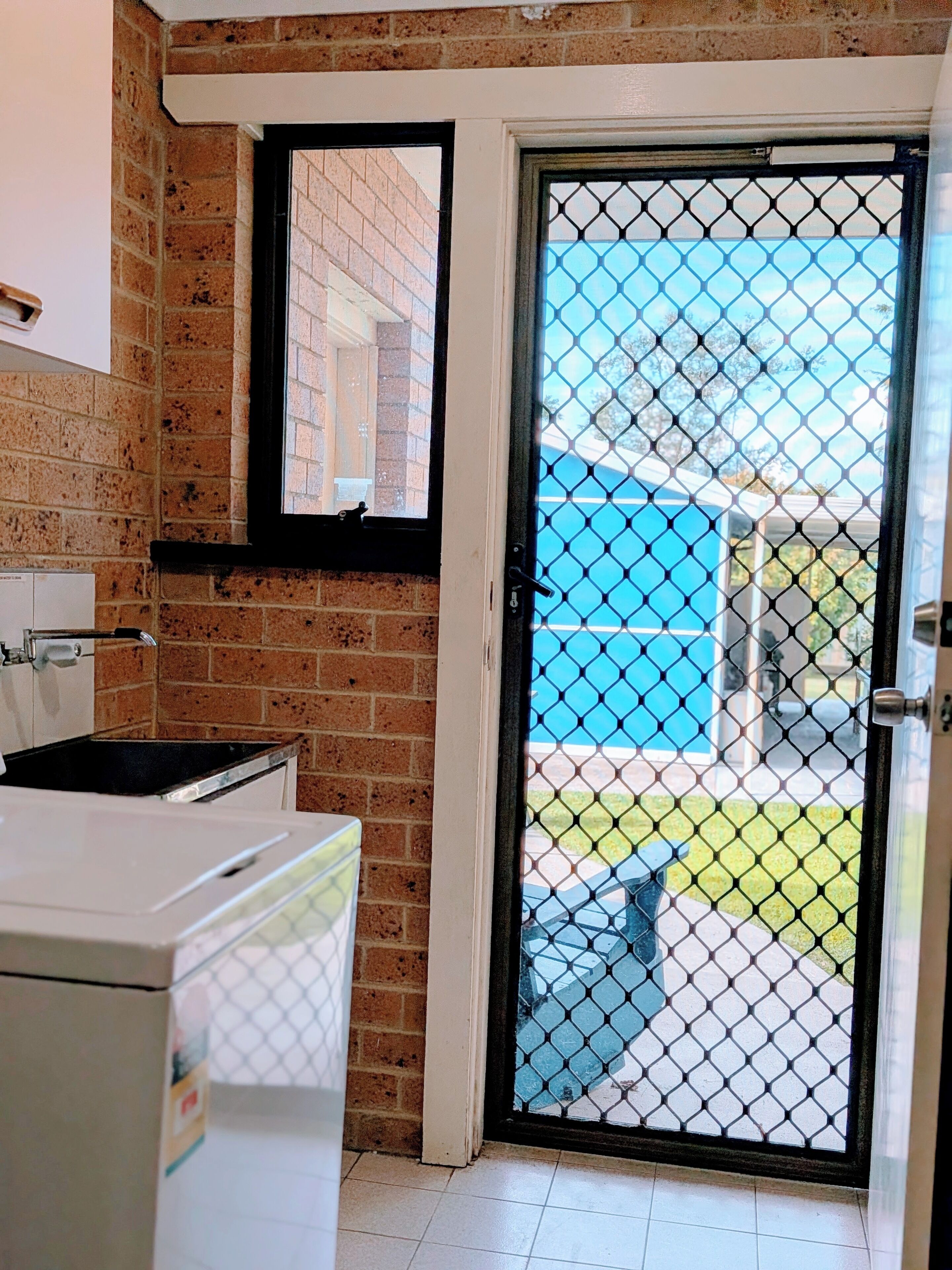 Una cocina con refrigerador, estufa y ventana con vista al exterior.