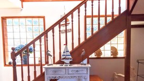 A wooden staircase with a white console table at the bottom. - 3 Min walk to the beach,  this little slice of heaven is your perfect getaway! (Culburra Beach)