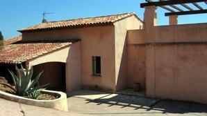 A building with a tiled roof, a pergola, and a small window. - Residential villa with big swimming-pool in Antheor, Southern France (Saint-Raphaël)