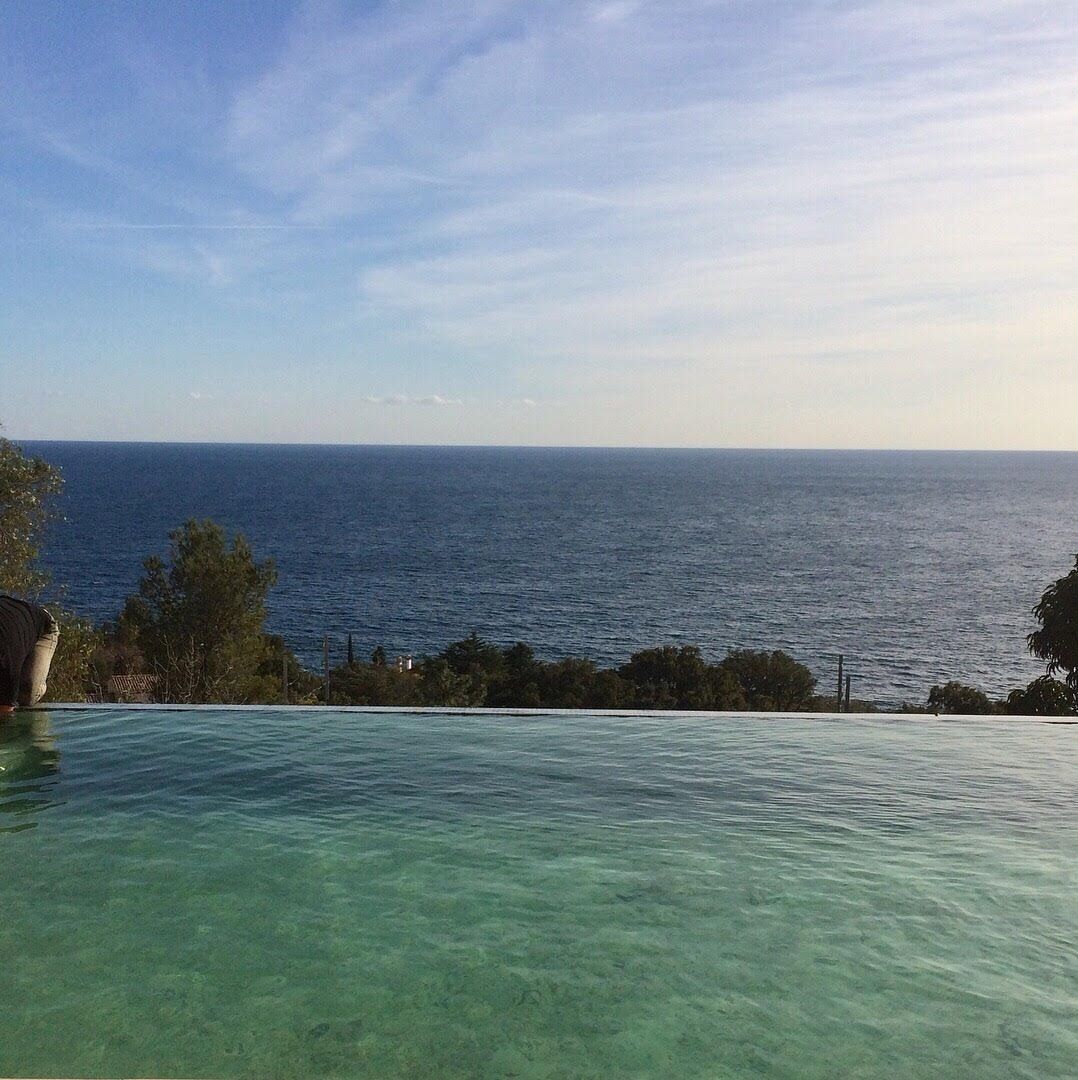 A clear view of the ocean from a poolside area.