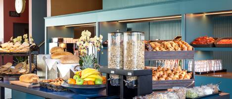 A buffet with various food items and a coffee station.