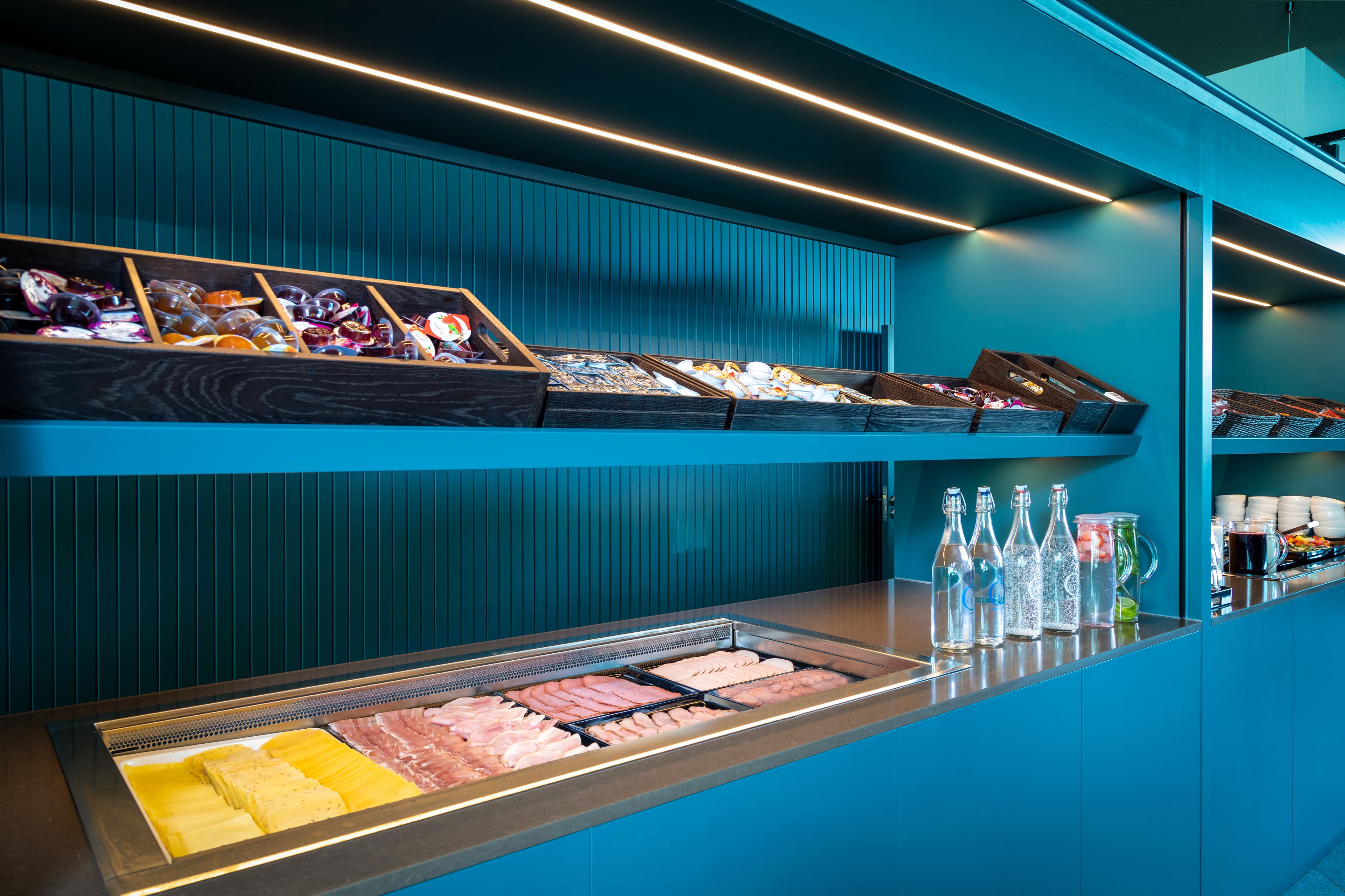 Ein Buffet mit verschiedenen Speisen und klaren Glasflaschen auf der Theke.