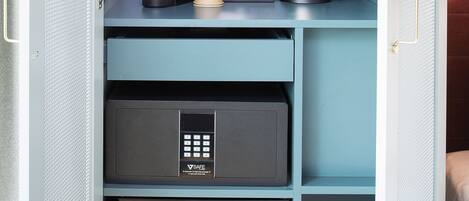 Un minibár compacto con cafetera, hervidor de agua y un refrigerador pequeño.