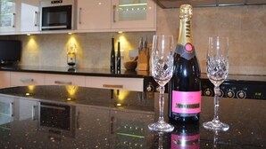 A kitchen with a modern design, featuring a black countertop, a microwave, and a gas stove. - The Cotswold Manor Lodge, Exclusive Hot Tub, Games Barn, 70 acres of Parkland (Bampton)