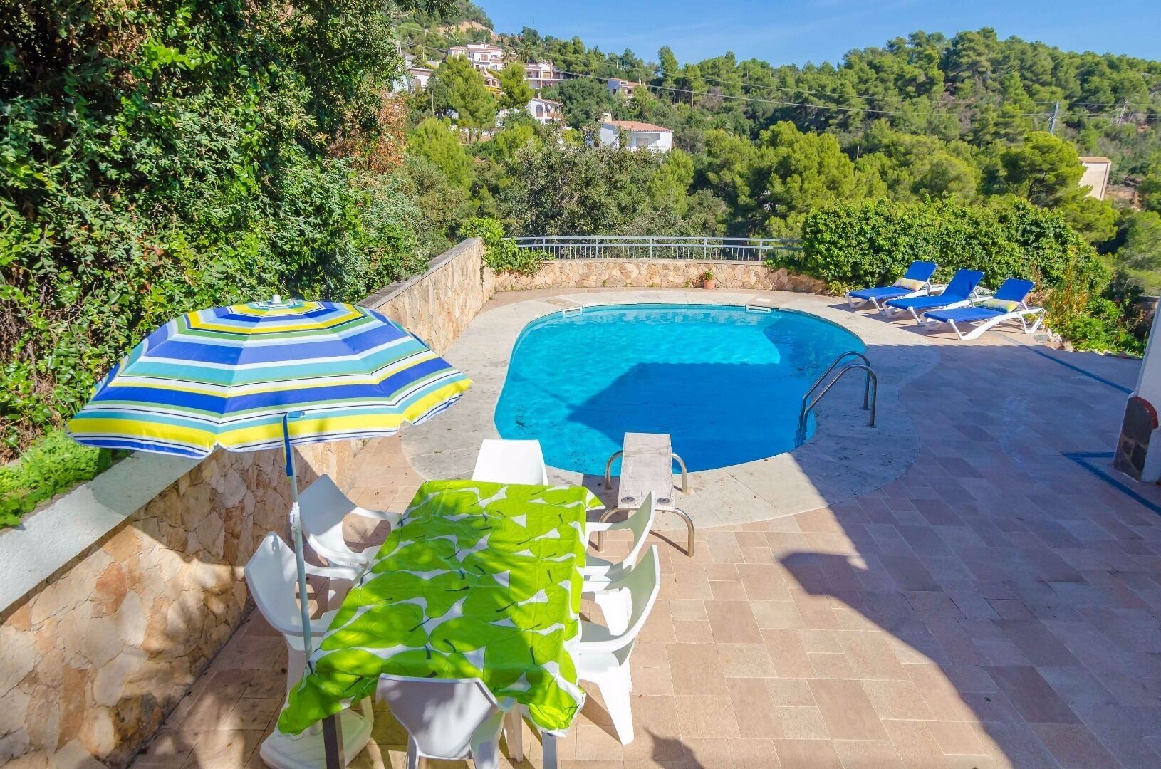 Zona de piscina con vistas a casas al fondo.