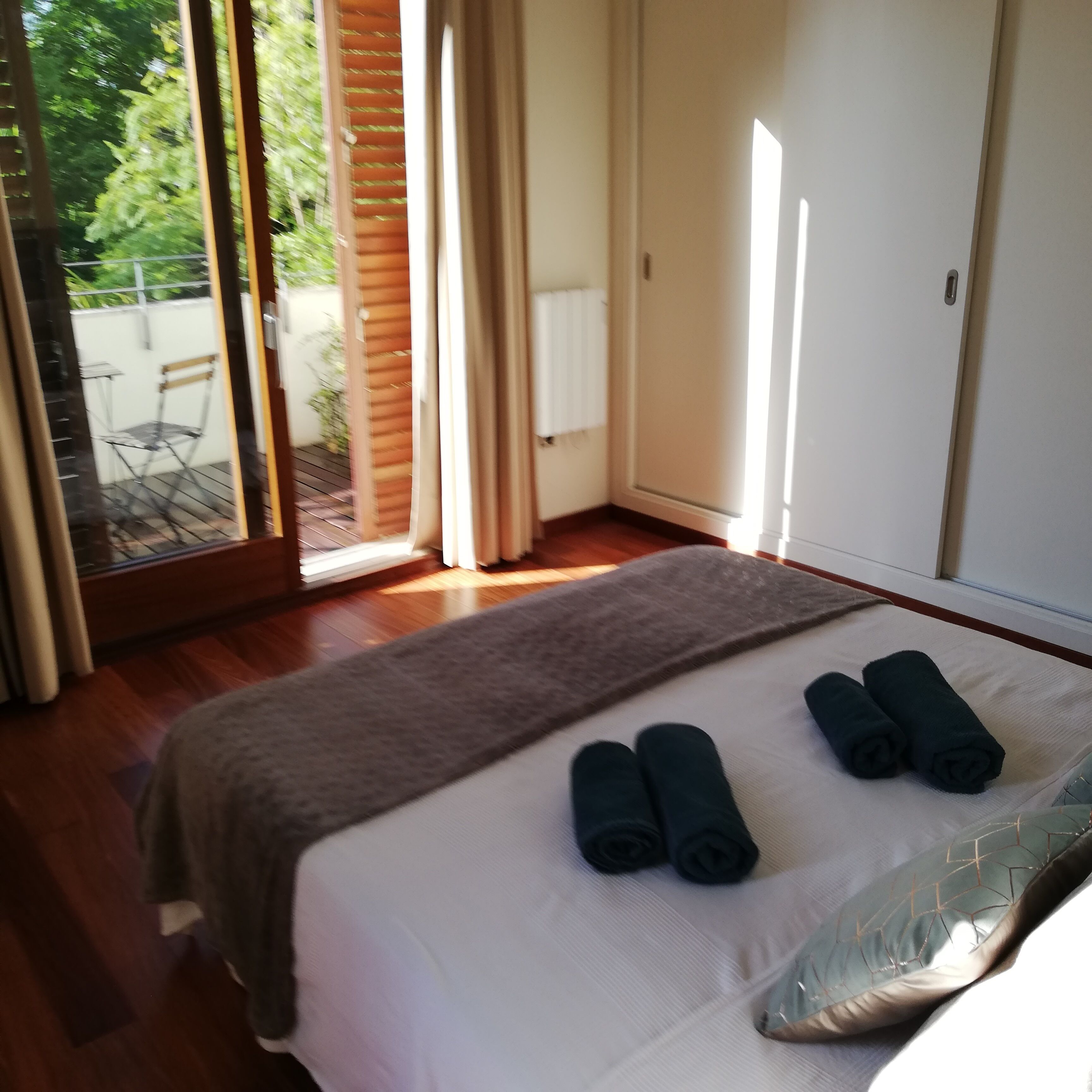 Un dormitorio con cama, ventana y vistas al exterior.