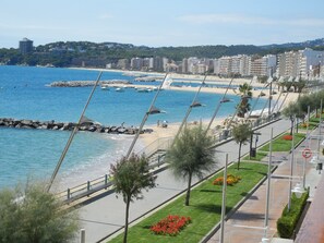 A coastal promenade with a beach, a rocky breakwater, and a row of buildings in the background. - Villa in beautiful location with sea views, heated pool, high-speed WIFI (Calonge)