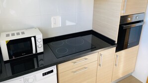 Una cocina moderna con microondas, estufa, horno y armarios de madera.