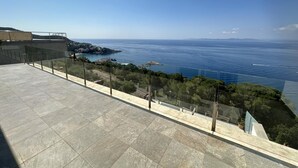 Une terrasse offrant une vue dégagée sur la mer et le paysage lointain.