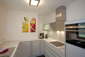 Eine moderne Küche mit Einbauofen, Mikrowelle und Kaffeemaschine.