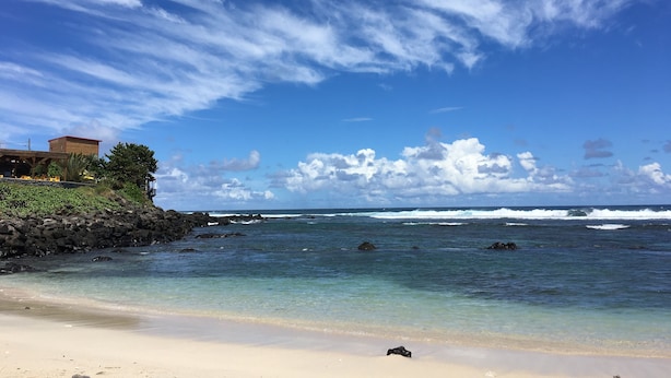 Una playa con cielo despejado y olas del océano.
