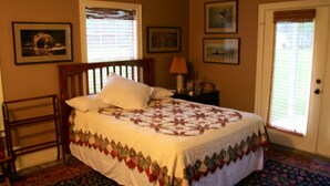 A bedroom with a bed, a nightstand, a lamp, a chair, and a door with blinds. - Relaxing getaway in a peaceful spacious setting (Long Beach)