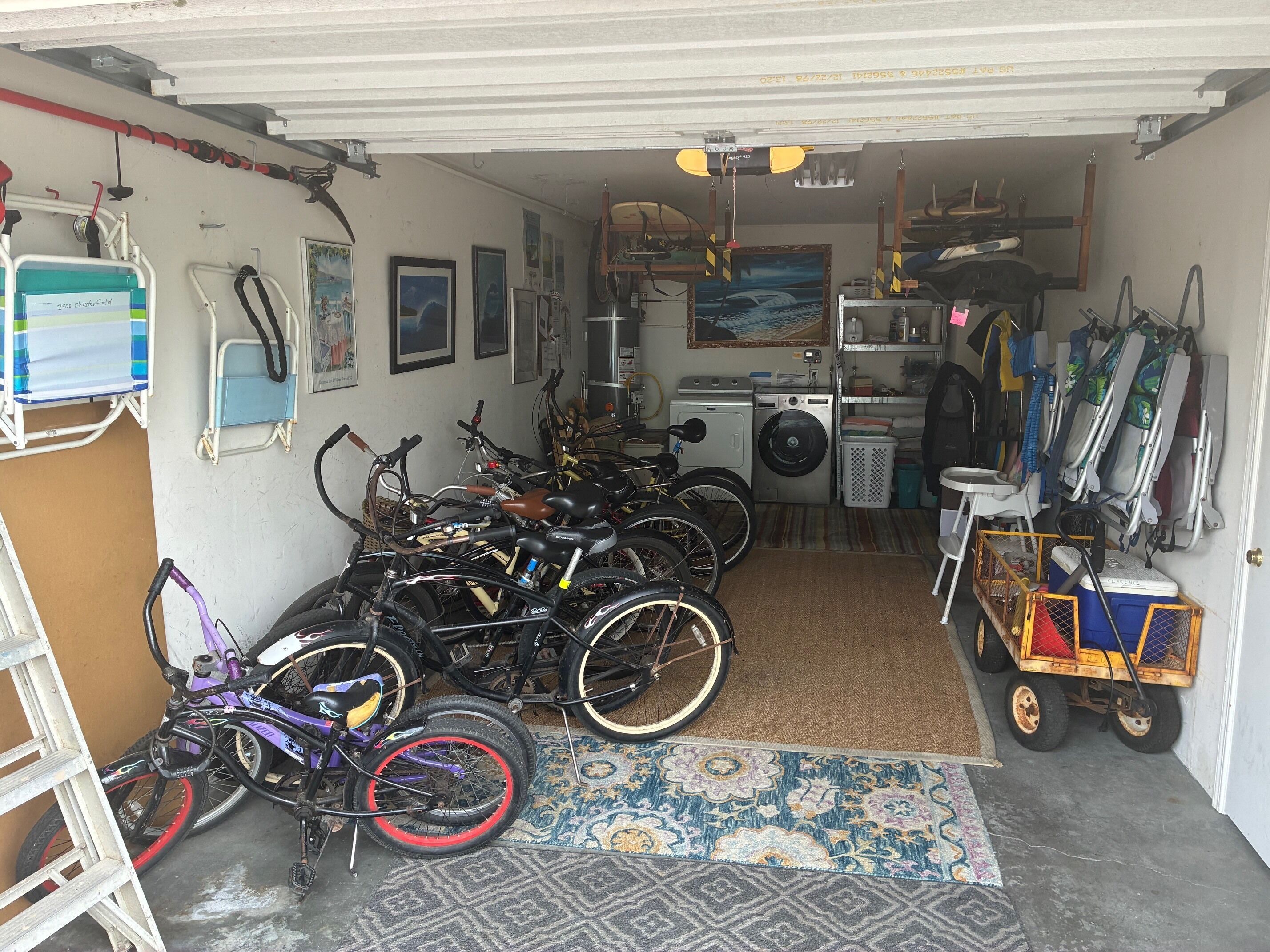 Eine Garage mit Fahrrädern, einer Waschmaschine und einem Wagen.