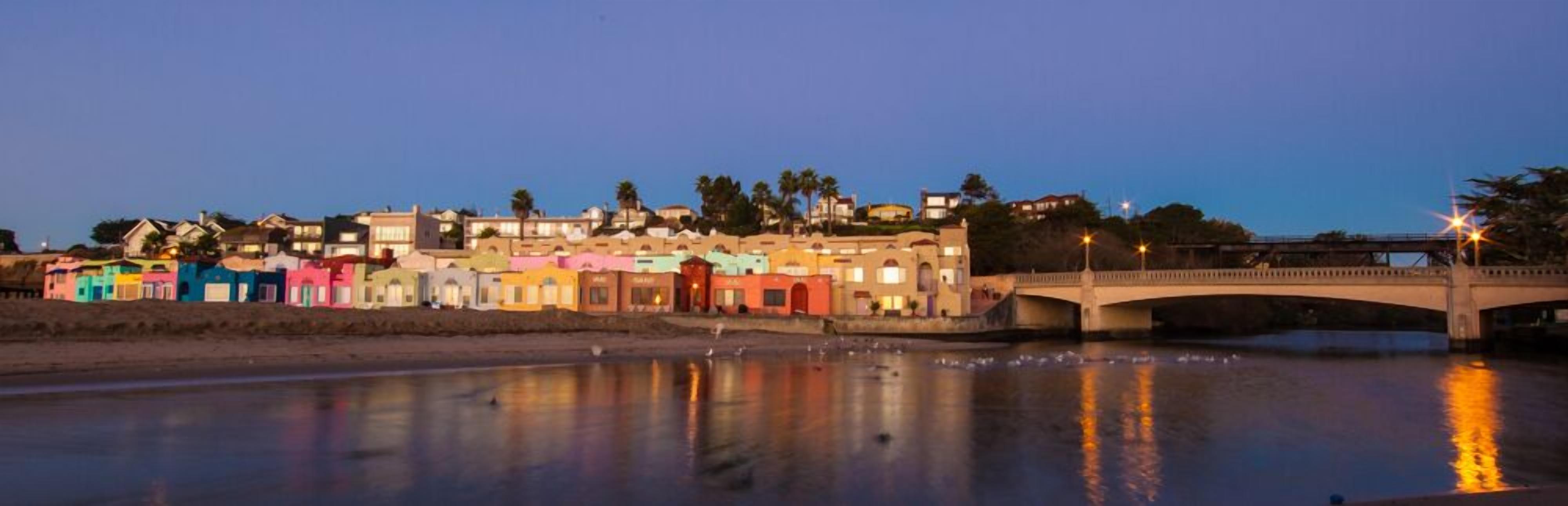 A waterfront area with colorful buildings and a bridge.