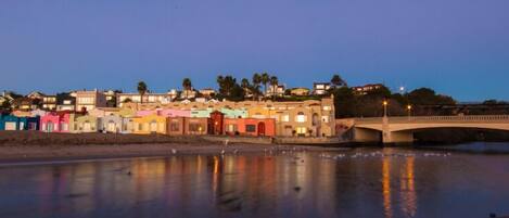 A waterfront area with colorful buildings and a bridge.