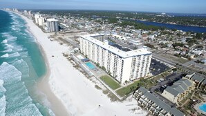 Un hôtel situé sur la côte, doté d’une piscine, offrant une vue sur la plage et comprenant plusieurs étages.